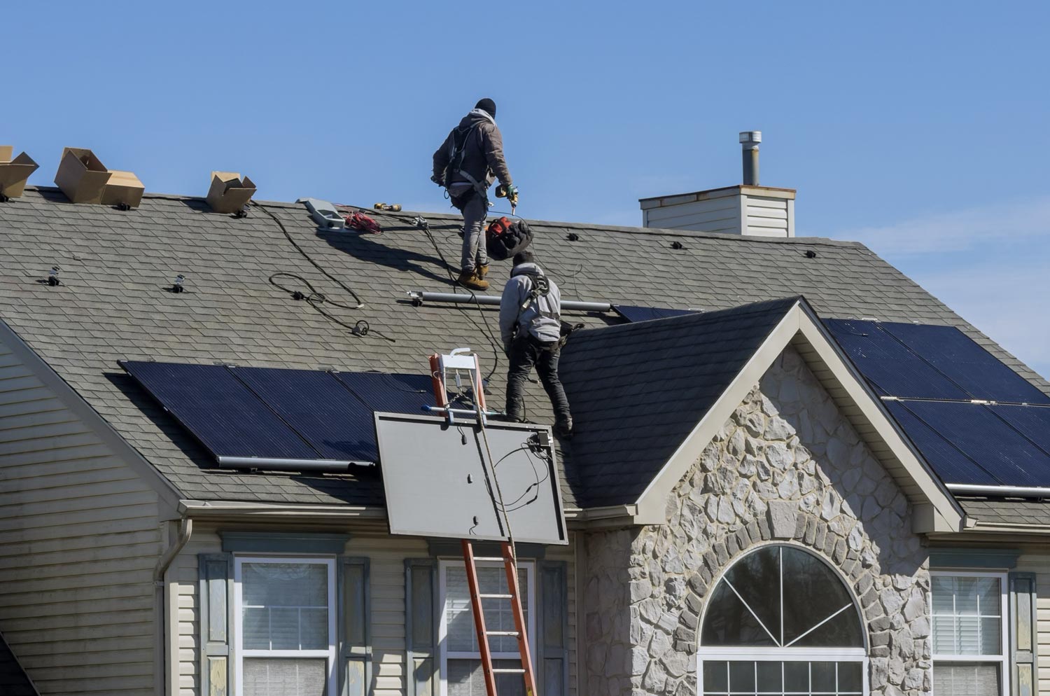 people installing solar panels on a home